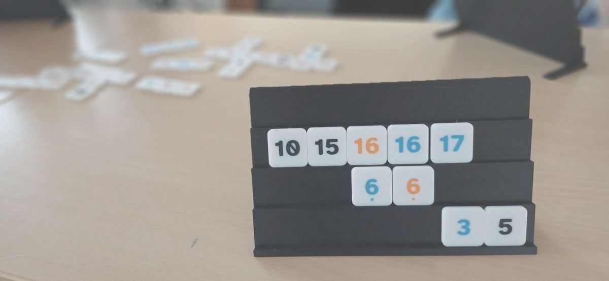 Eine Spielbank vor dem Tisch, dahinter liegen die Reihen der laufenden Partie