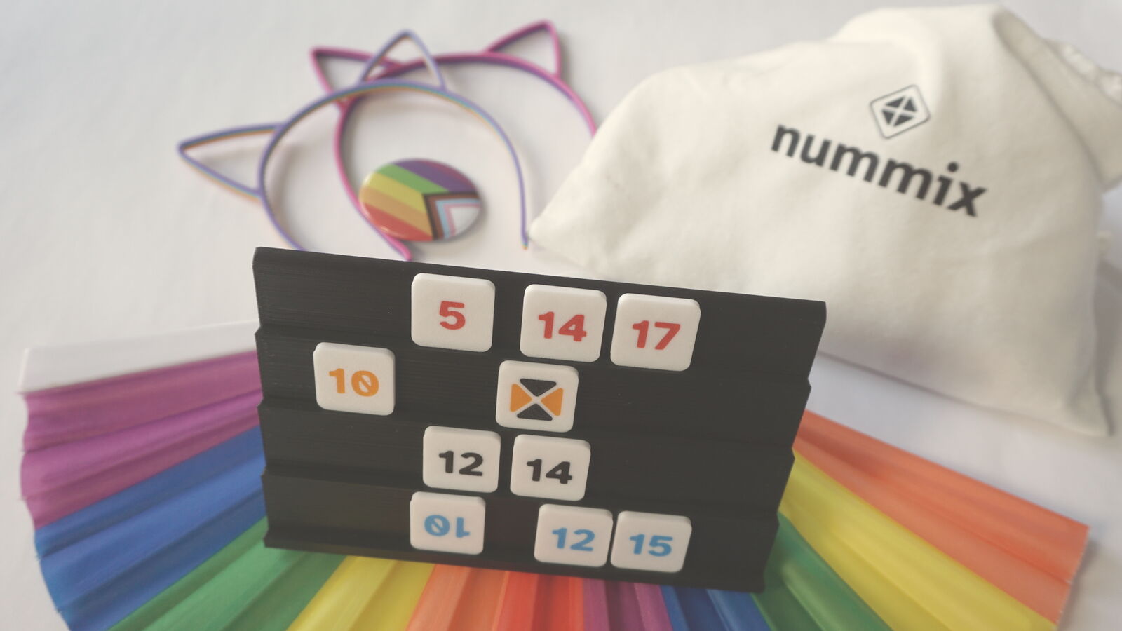 Spielbank mit Zahlensteinen vor einem Regenbogenfächer, als Kreuz zugeschnitten